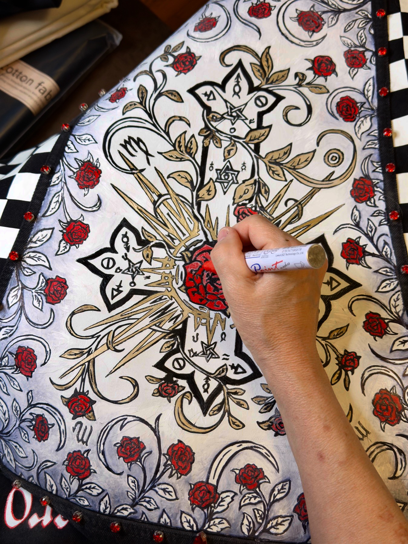 Debbi Cohilas hand-painting the back panel of the jacket in the atelier