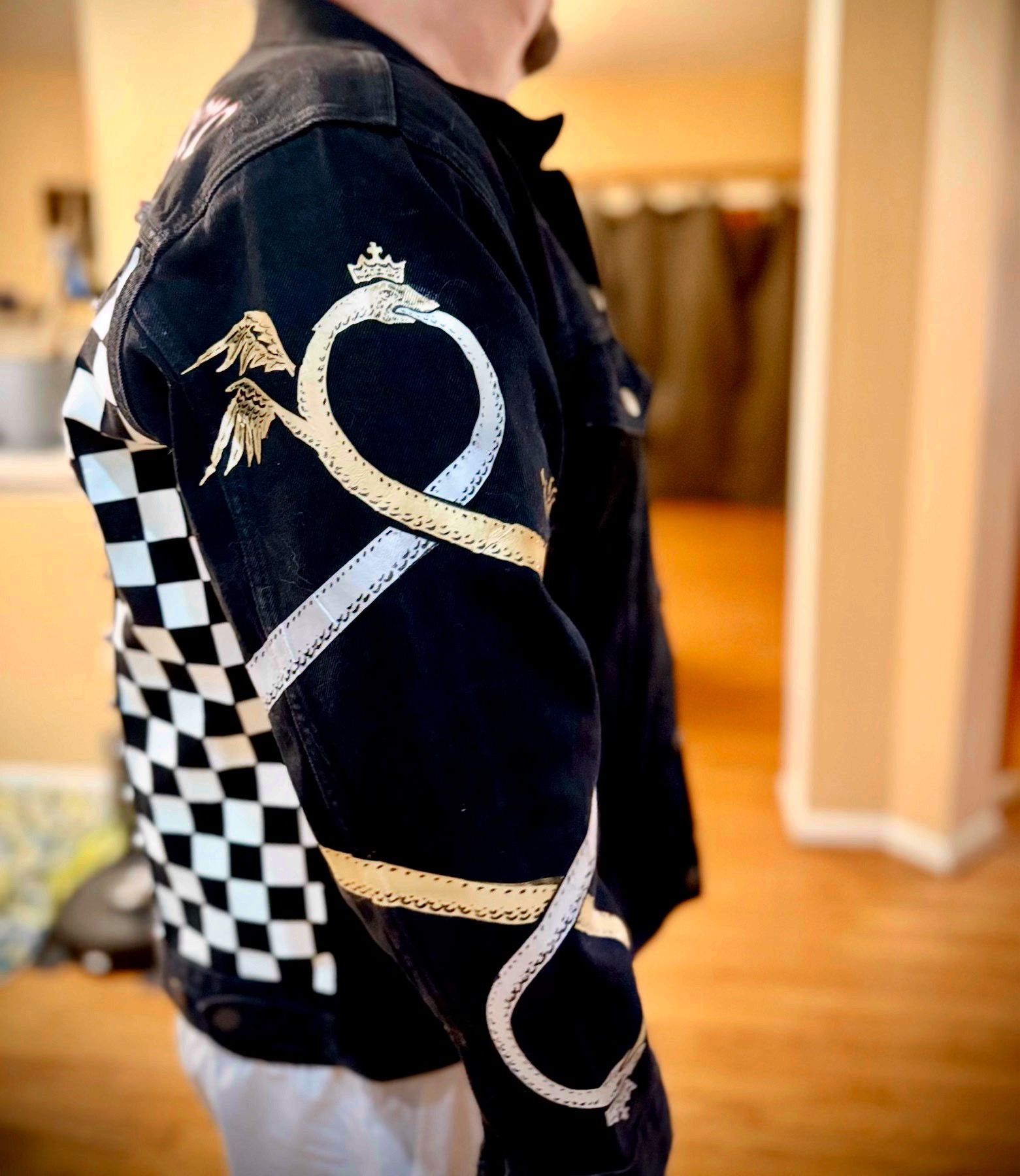 Serpent sleeve detail — a crowned serpent beside a checkerboard panel