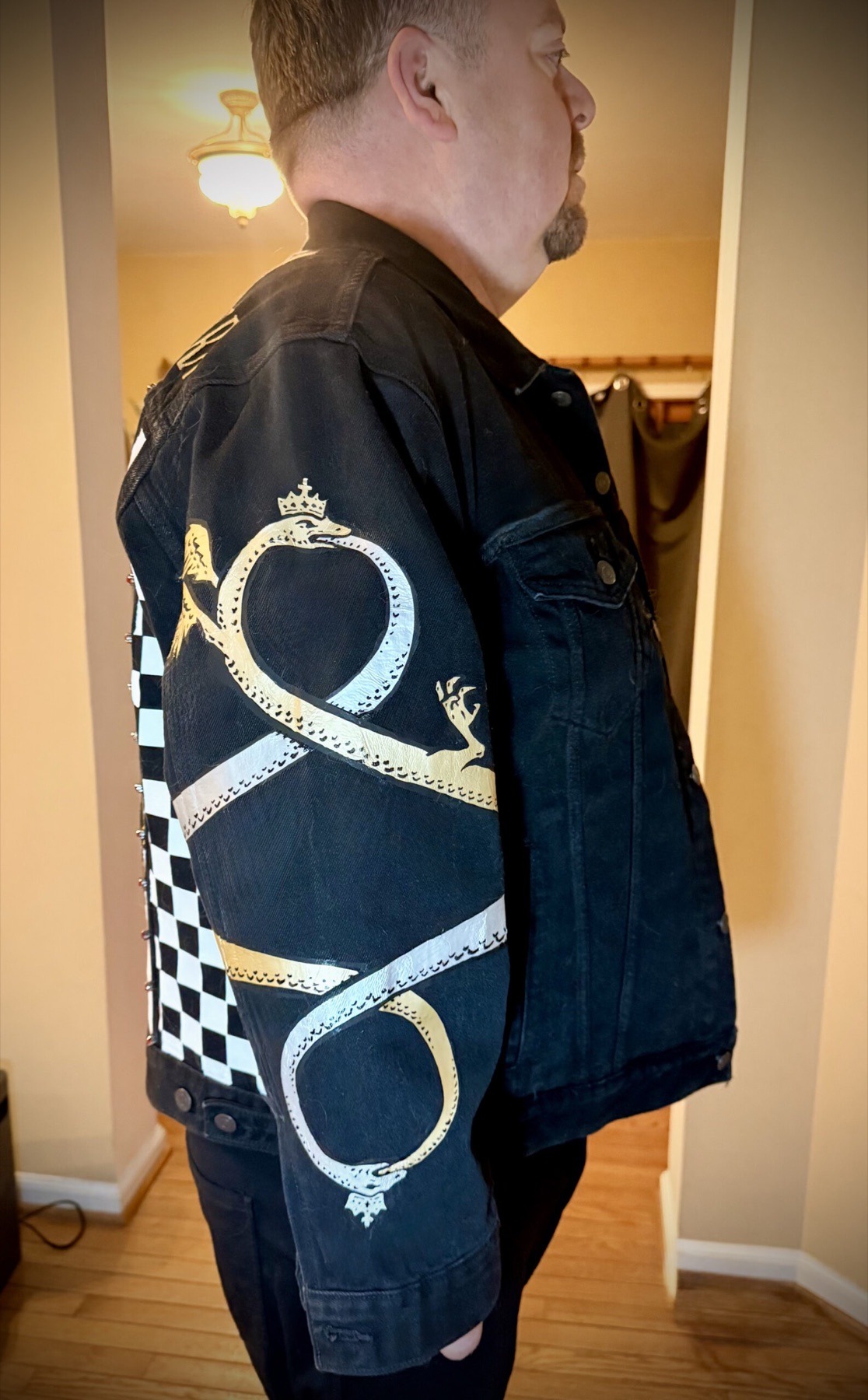 Pelican Battle Jacket — serpent sleeve detail, crowned serpents beside a checkerboard panel